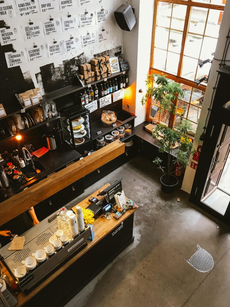 pexels-photo-2199190-2199190 High angle view of a modern coffee shop interior with a wooden counter and cozy furnishings, ideal for business and leisure.