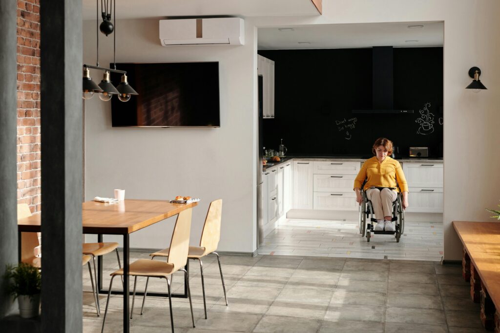pexels-photo-4063489-4063489 A woman in a wheelchair in a stylish, modern kitchen setting, emphasizing accessibility.
