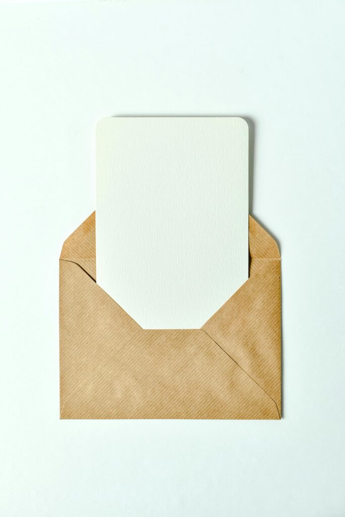pexels-photo-7958169-7958169 Minimalist brown envelope showcasing a blank card insert - perfect for invitations or greetings.