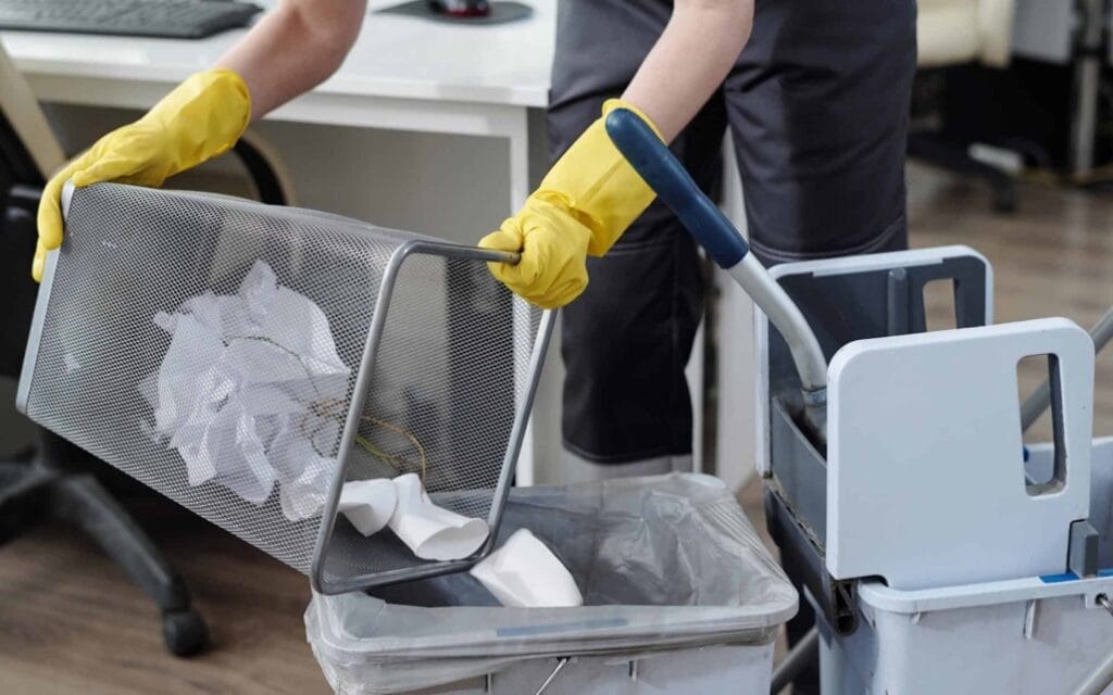 cleaning-service-person-emptying-office-trash-bins