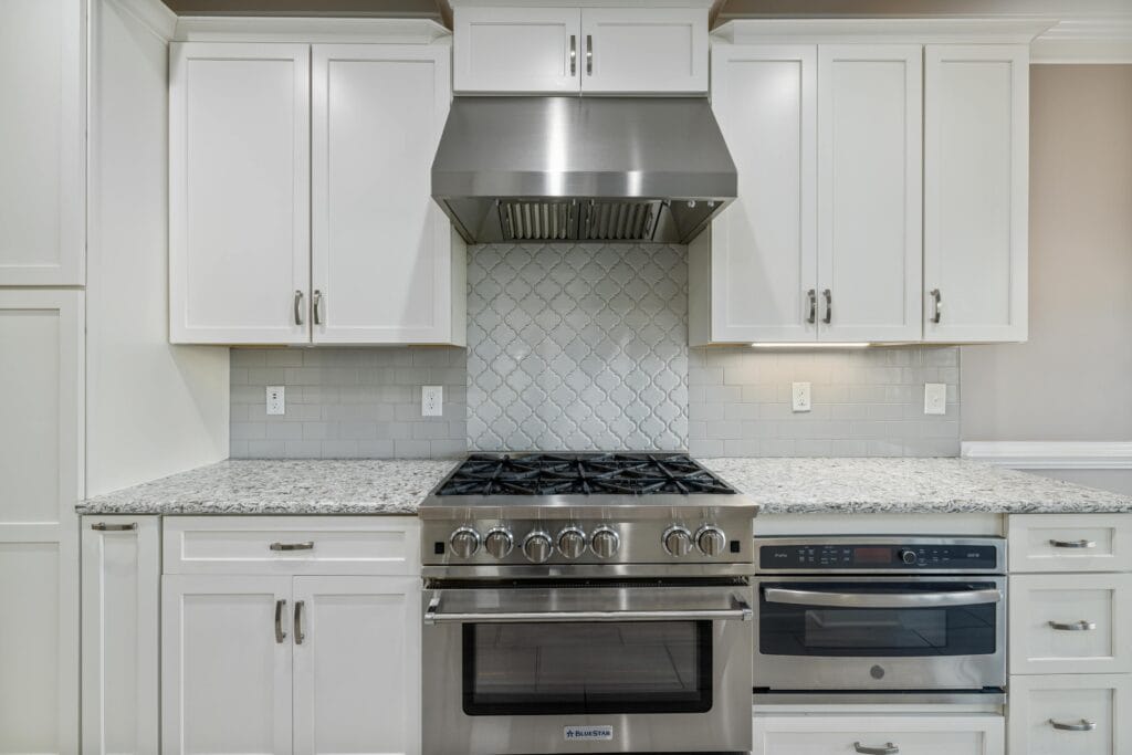 pexels-photo-10827395-10827395 Elegant kitchen with stainless steel oven and white cabinets accentuated by sleek design.