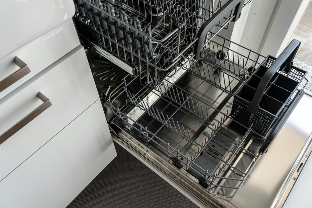 pexels-photo-3829549-3829549 A clean and empty stainless steel dishwasher open in a modern kitchen setting.