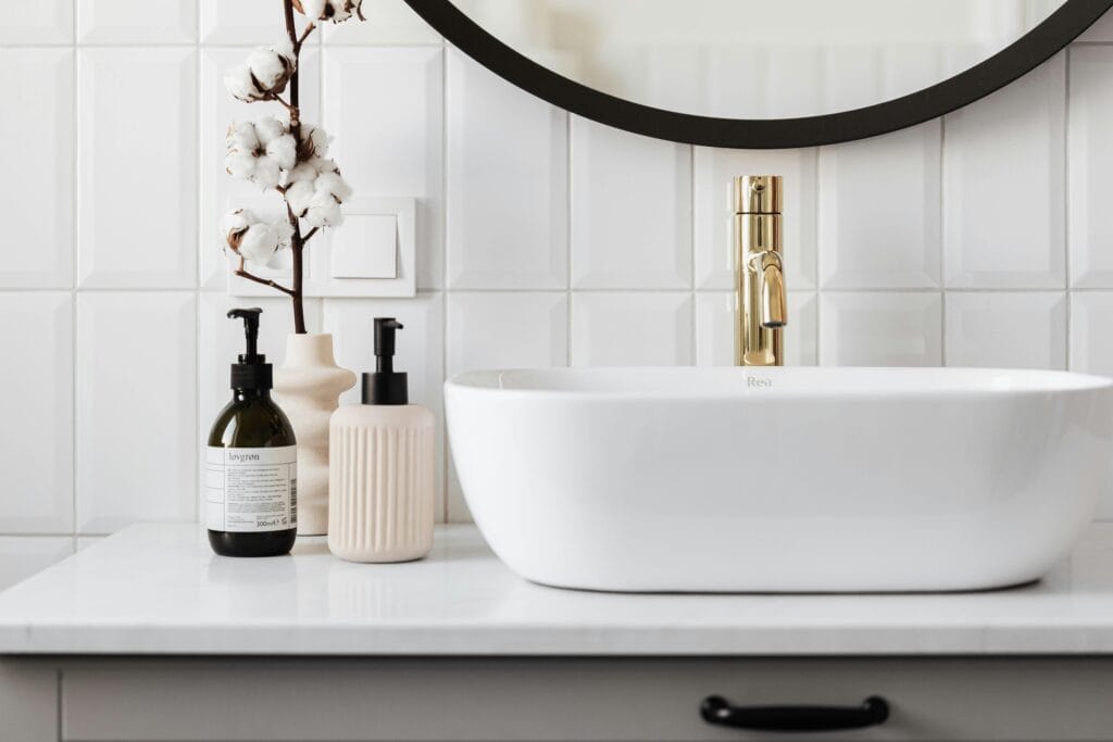 pexels-photo-4194712-4194712 Stylish minimalist bathroom with a ceramic basin and modern gold faucet.