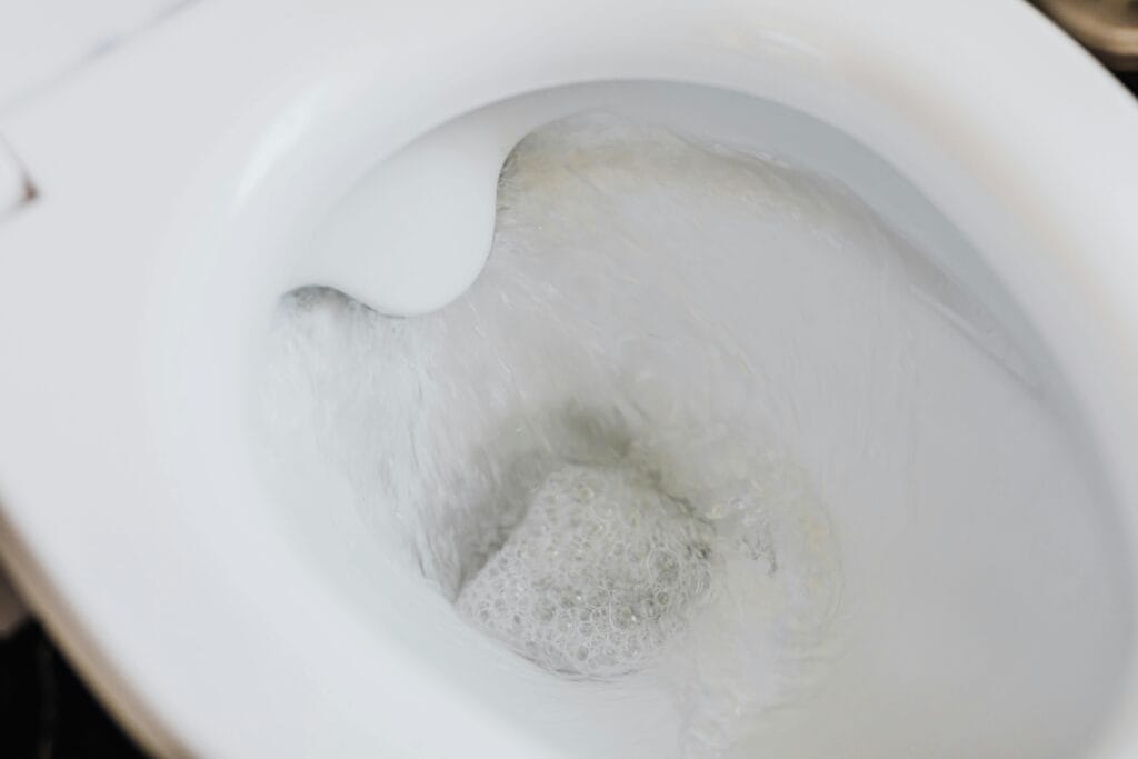 pexels-photo-4239015-4239015 High-angle view of a toilet flushing with swirling water and bubbles, showcasing cleanliness.